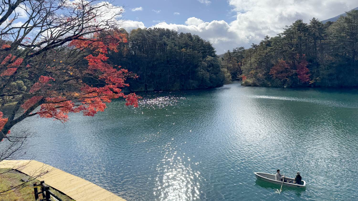 木々の紅葉を映す毘沙門沼とボート
